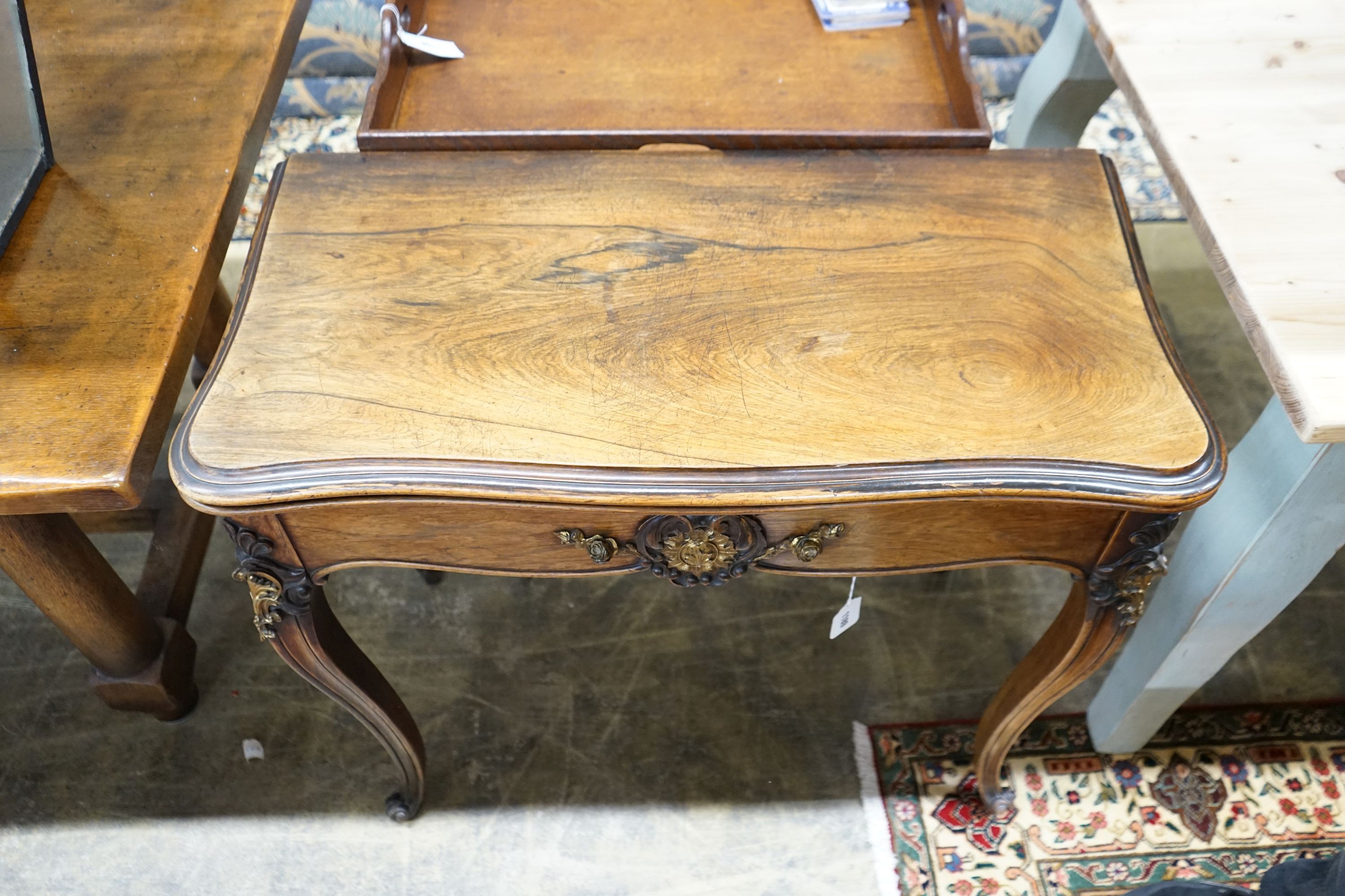 A 19th century French gilt metal mounted rosewood serpentine folding card table, width 82cm, depth 41cm, height 76cm